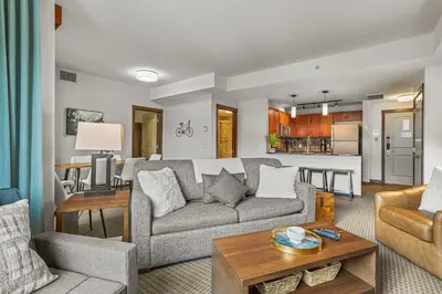 a living room with a couch and a table at Romantic Mountain Escape - Hot Tubs & Private Balcony! managed by Little Sister Getaways in Canmore