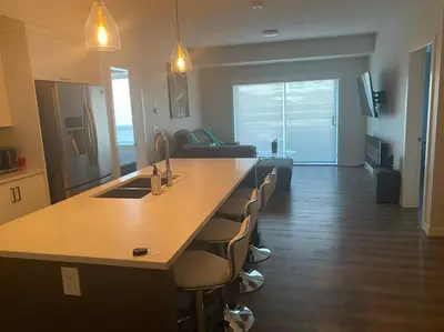 a kitchen with a large island in a living room at Spacious 2-bed, 2-bath condo in downtown Kelowna! in Kelowna