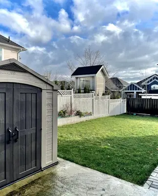 a garage in a yard with a fence at Blissful Stay in Surrey in Surrey