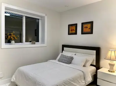 a white bedroom with a bed and a window at Blissful Stay in Surrey in Surrey