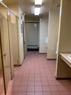 a hallway of a bathroom with stalls and sinks at Cascade Lodge with front desk check in services, ski valet service, boot and glove dryer, 2 hot tubs, year round heated pool, gym, sauna, change rooms & showers, WIFI, cable TV in Whistler