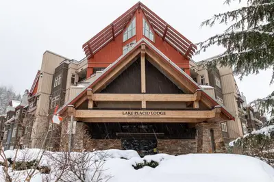 a house in the winter with snow on the ground at Creekside Slopeside 1BR with pool, hot tub, BBQ in Whistler