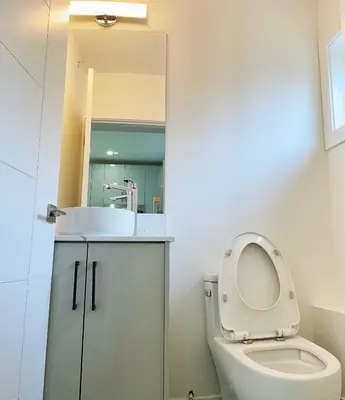 a bathroom with a white toilet and a sink at Vancouver’s Homey Laneway House in Vancouver