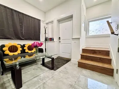 a living room with a couch and flowers on a glass table at Vancouver’s Homey Laneway House in Vancouver