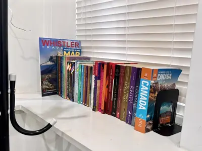 a row of books sitting on a shelf at Vancouver’s Homey Laneway House in Vancouver