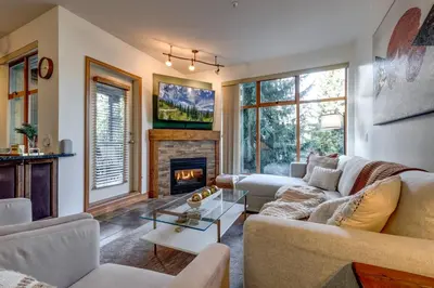 a living room with a couch and a fireplace at Central 2BR with Prime Amenities in Whistler