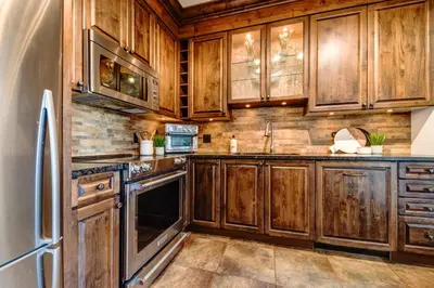 a kitchen with wooden cabinets and a refrigerator at Central 2BR with Prime Amenities in Whistler