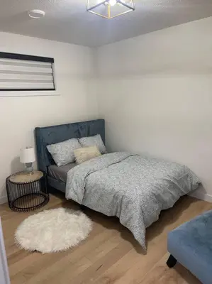 a bedroom with a bed and a couch at Stylish 2 Bedroom suite in SW Edmonton close to Windermere and Edmonton International Airport in Edmonton