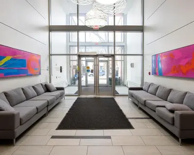 a lobby with two couches and a glass door at Hendrix Luxury Apartments by Corporate Stays in Edmonton