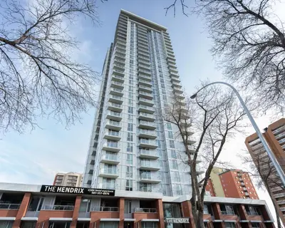 a tall building with a sign in front of it at Hendrix Luxury Apartments by Corporate Stays in Edmonton