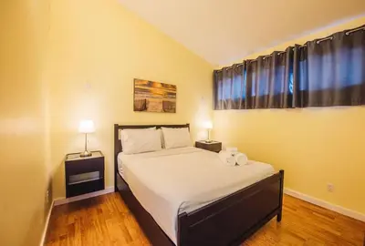 a bedroom with a bed with two lamps and a window at The Niven Lake Retreat in Yellowknife