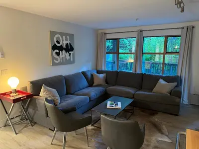 a living room with a blue couch and chairs at Beautiful 1BR 1BA Apartment at NORTHSTAR-Whistler, BC in Whistler