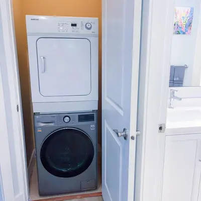 a washer and dryer in a room with a door at Ground level two bedrooms Suite near Lake and Golf Course in Victoria