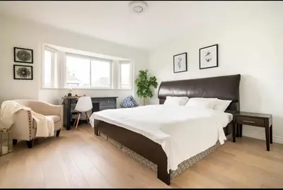 a bedroom with a large bed and a chair at Richmond Cozy Place 2 in Richmond