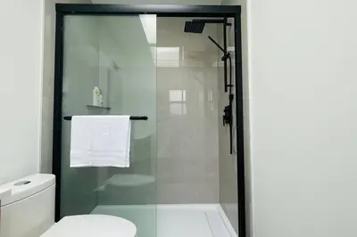 a bathroom with a glass shower with a toilet at Richmond Cozy Place 2 in Richmond