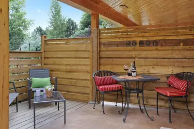 a patio with two tables and chairs and a fence at Uncork and Unwind in West Kelowna