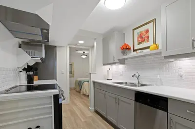 a white kitchen with a sink and a counter top at Uncork and Unwind in West Kelowna