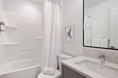 a white bathroom with a sink and a toilet at Beachfront Luxury Suite #19 at THE BEACH HOUSE in Campbell River