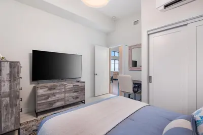 a bedroom with a flat screen tv and a bed at Beachfront Villa #14 at The Beach House in Campbell River