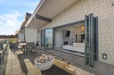 a patio with a view of a living room at Beachfront Villa #14 at The Beach House in Campbell River