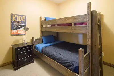 a bedroom with two bunk beds and a night stand at Luxury Aspens 2 Bdrm Condo with Best Views in Big White