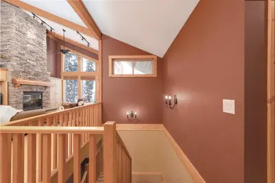 a wooden staircase in a home with a fireplace at Eagle Ridge Pet-Friendly Chalet in Big White