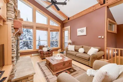 a living room with a couch and a table at Eagle Ridge Pet-Friendly Chalet in Big White