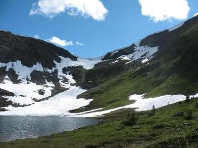 a mountain with snow on the side of a river at Right Choice Home Valemount in Valemount