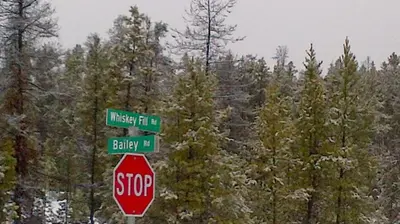 a stop sign with two street signs on top of it at Right Choice Home Valemount in Valemount