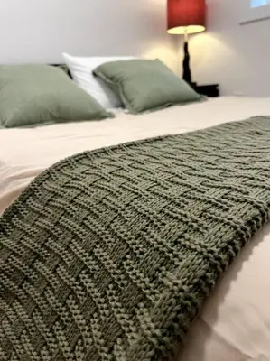 a bed with a blanket on top of it at Grand Boulevard Basement Suite in North Vancouver