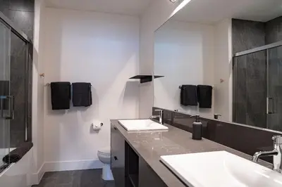 a bathroom with two sinks and a toilet at Escape to Revy - Beautifully Designed Condo in Revelstoke