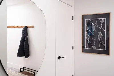 a hallway with a white door and a mirror at Escape to Revy - Beautifully Designed Condo in Revelstoke