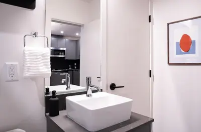 a bathroom with a white sink and a mirror at Snow & Swing Getaway - Three Bedrooms with Hot Tub (Stay Revy) in Revelstoke