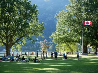 a group of people in a park with a canadian flag at Dancing Bear Inn in Nelson