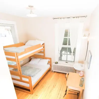 a small room with a bunk bed and a desk at Dancing Bear Inn in Nelson