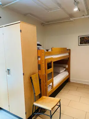a bunk bed and a chair in a room at Dancing Bear Inn in Nelson