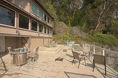 a patio with chairs and a table and a table and chairs at Exclusive Private Island - Pacific Ocean Paradise in Madeira Park