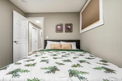 a bedroom with a bed with a green and white comforter at Newly renovated 2 bedroom basement suite in Calgary
