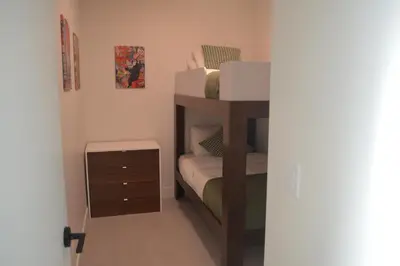 a small bedroom with a bunk bed and a night stand at Stokeside Serenity in Revelstoke