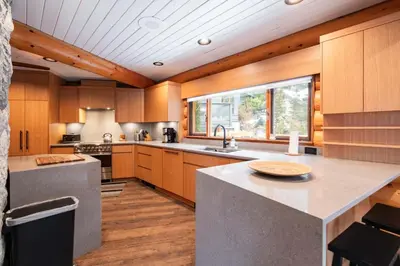 a large kitchen with wooden cabinets and a large island at Snowridge Chalet by Outpost Whistler in Whistler