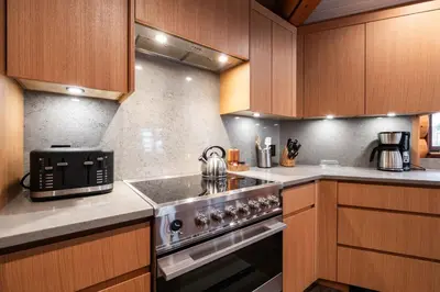 a kitchen with wooden cabinets and a stove top oven at Snowridge Chalet by Outpost Whistler in Whistler