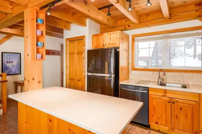 a kitchen with a sink and a refrigerator at Alpine Timber Luxury Chalet w/Hot Tub in Big White