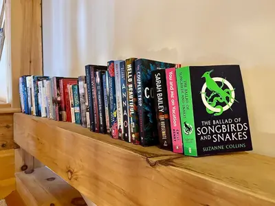 a row of books sitting on a wooden shelf at Alpine Timber Luxury Chalet w/Hot Tub in Big White