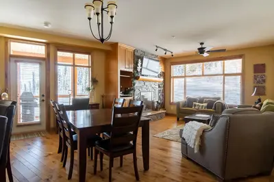 a dining room and living room with a table and chairs at The Aspens 5 w/ Hot Tub in Big White