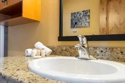 a bathroom counter with a sink and a mirror at The Aspens 5 w/ Hot Tub in Big White