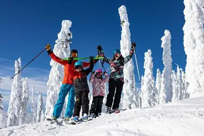 a group of people standing on a snow covered slope at The Aspens 5 w/ Hot Tub in Big White