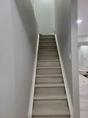 a staircase in a room with white walls and carpet at Brand New 2 Bedroom Basement Suite with Wifi in Edmonton