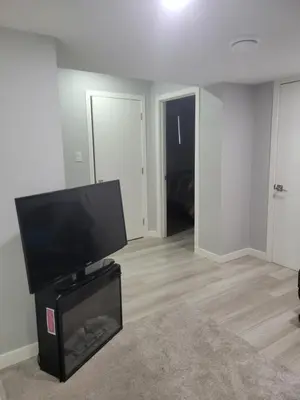 a living room with a flat screen tv on a stand at Brand New 2 Bedroom Basement Suite with Wifi in Edmonton