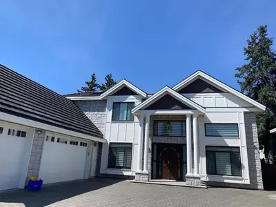 a large white house with a garage at Cozy and Private Suite in Richmond in Richmond