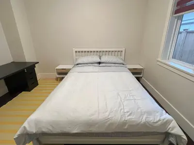 a white bed in a room with a window at Cozy and Private Suite in Richmond in Richmond